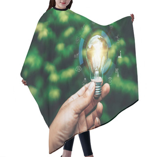Personality  Ecology Energy Efficiency Concept. Hand Holding Light Bulb Against Nature On Blurred Tree Background. Hair Cutting Cape