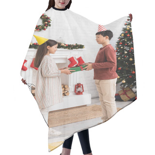 Personality  Multiethnic Children In Party Caps Holding Present Near Christmas Decor On Fireplace At Home  Hair Cutting Cape