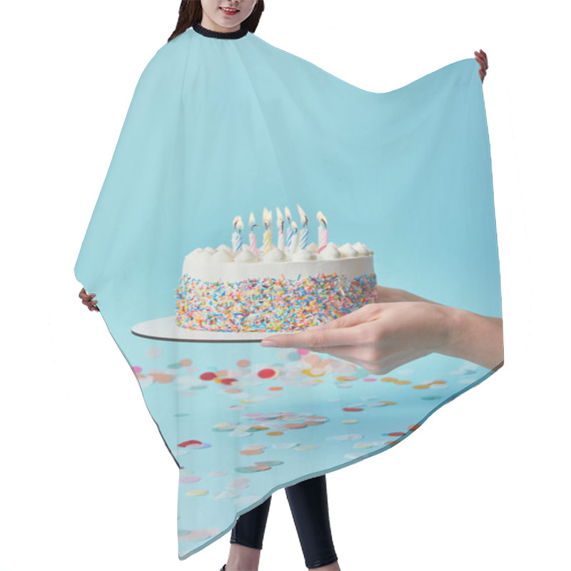 Personality  Cropped view of woman holding delicious birthday cake with candles on blue background with confetti hair cutting cape