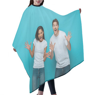 Personality  Cheerful Interracial Couple Showing Frightening Gestures At Camera On Blue Background Hair Cutting Cape