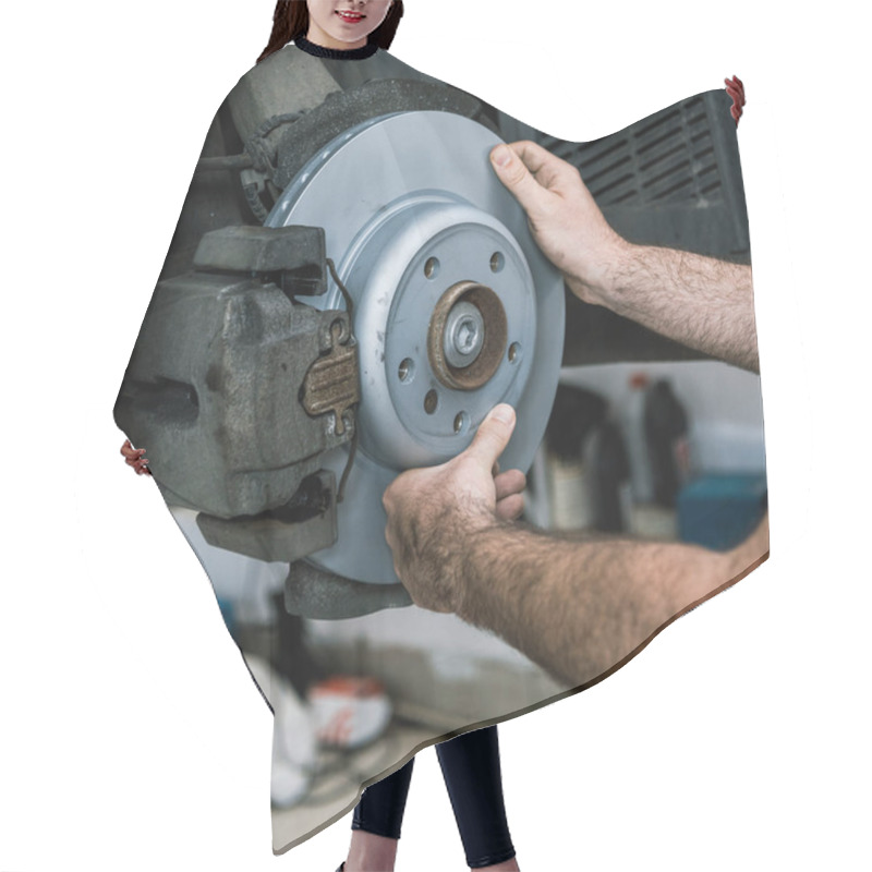 Personality  cropped view of auto mechanic holding metallic car brake near auto hair cutting cape