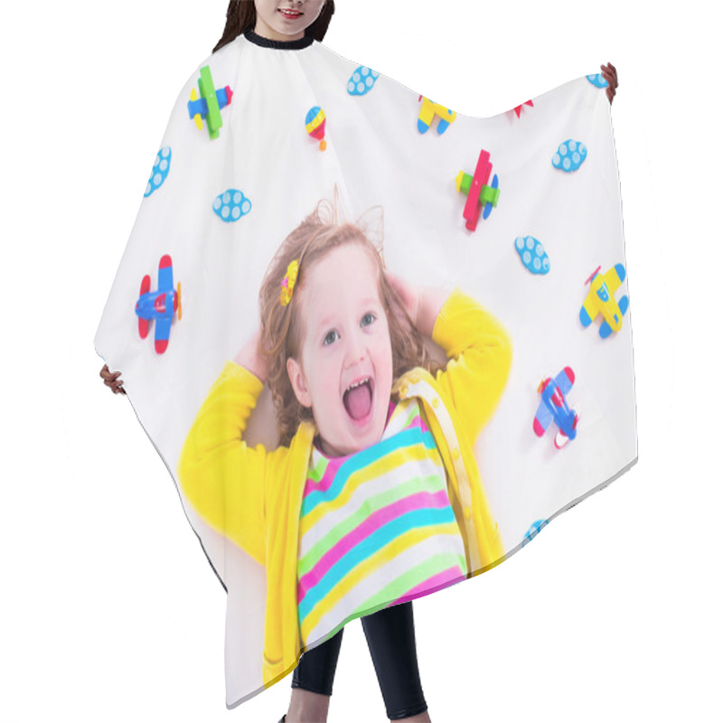 Personality  Little girl playing with wooden airplane hair cutting cape