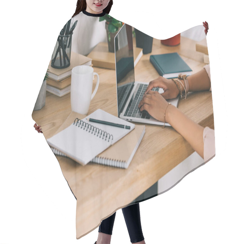 Personality  cropped image of african american businesswoman using laptop in office hair cutting cape