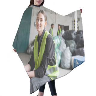 Personality  Cheerful Young Worker In Safety Vest And Gloves Looking At Camera While Resting And Sitting Near Blurred Plastic Bags In Garbage Sorting Center, Recycling Concept Hair Cutting Cape