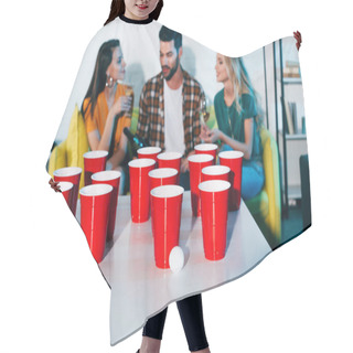 Personality  Close-up View Of Plastic Cups And Ball For Beer Pong And Young Friend Drinking Wine Behind Hair Cutting Cape