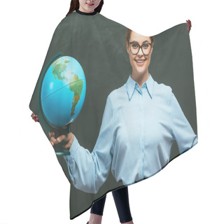 Personality  Happy Young Teacher Standing Near Chalkboard With Hand On Hip And Holding Globe Hair Cutting Cape