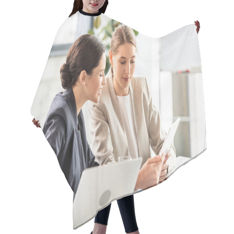 Personality  two smiling businesswomen in formal wear at table in office hair cutting cape