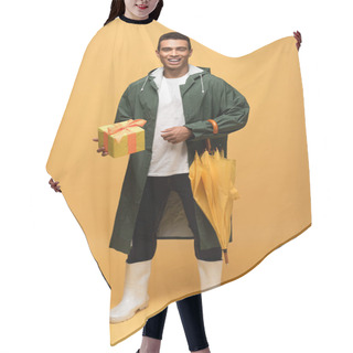 Personality  Mixed Race Man In Raincoat And Rubber Boots Holding Gift Box And Umbrella Isolated On Yellow Hair Cutting Cape