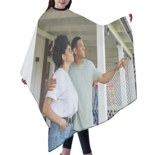 Personality  Smiling African American Man Hugging And Pointing Near Girlfriend On Porch Of New House Hair Cutting Cape