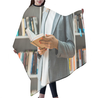 Personality  Cropped View Of Woman Holding Book And Standing In Library  Hair Cutting Cape