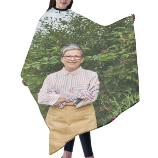 Personality  Jolly Mature Woman In Casual Attire With Glasses Holding Rakes For Gardening And Smiling At Camera Hair Cutting Cape