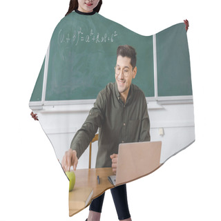 Personality  Smiling Male Teacher In Glasses Sitting At Computer Desk And Reaching For Apple In Classroom Hair Cutting Cape