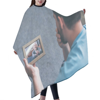 Personality  Back View Of Adult Man Grieving While Looking At Photo Frame With Old Man At Home Hair Cutting Cape