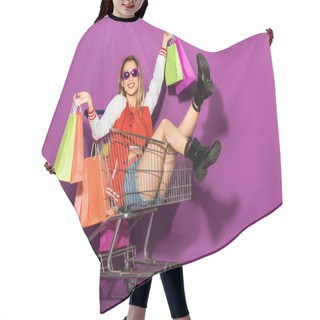 Personality  Beautiful Young Woman In Sunglasses Holding Shopping Bags And Sitting In Shopping Trolley On Violet  Hair Cutting Cape