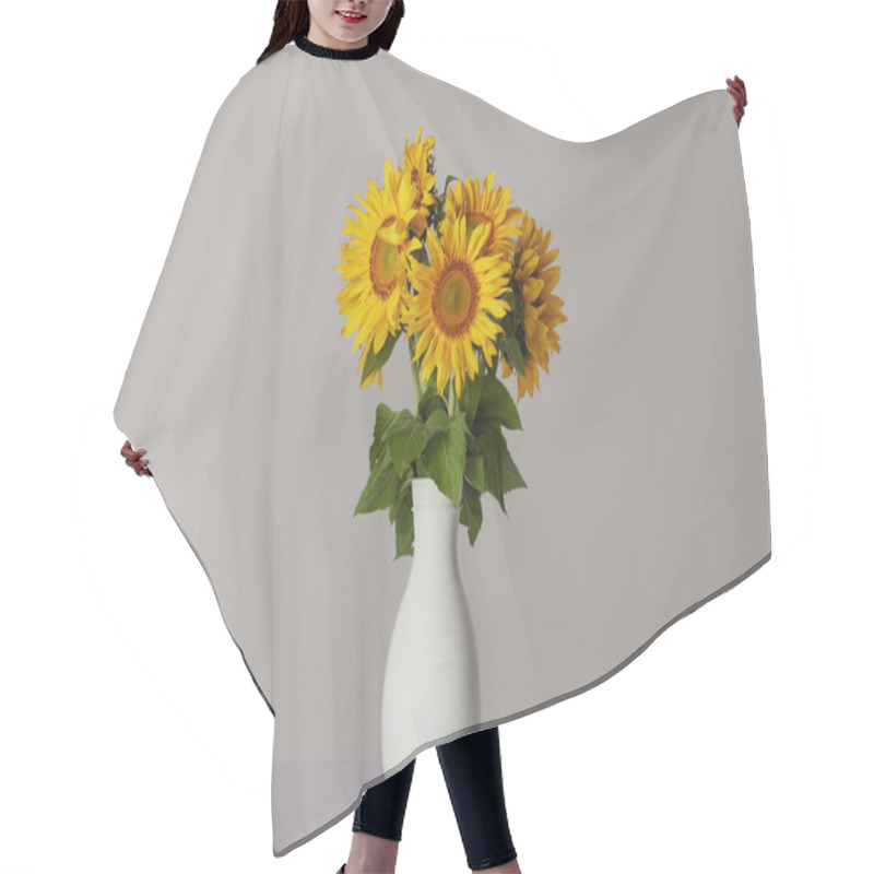 Personality  bouquet of yellow sunflowers in white vase, on grey hair cutting cape