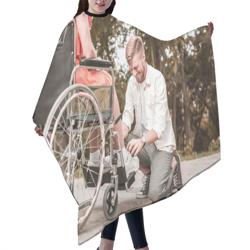 Personality  Young Man Smiling While Tying Shoelaces Of Disabled Girlfriend Hair Cutting Cape