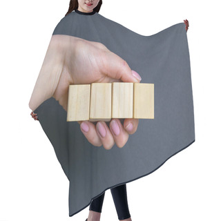Personality  Hand Holds 4 Wooden Cubes On A Black Background, Space For Text. Hair Cutting Cape
