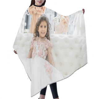 Personality  Cheerful Middle Eastern Girl With Curly Hair Sitting In Floral Dress On White Couch And Smiling Inside Of Luxurious Wedding Salon, Smiling Kid, Tulle Skirt, Blurred Background  Hair Cutting Cape