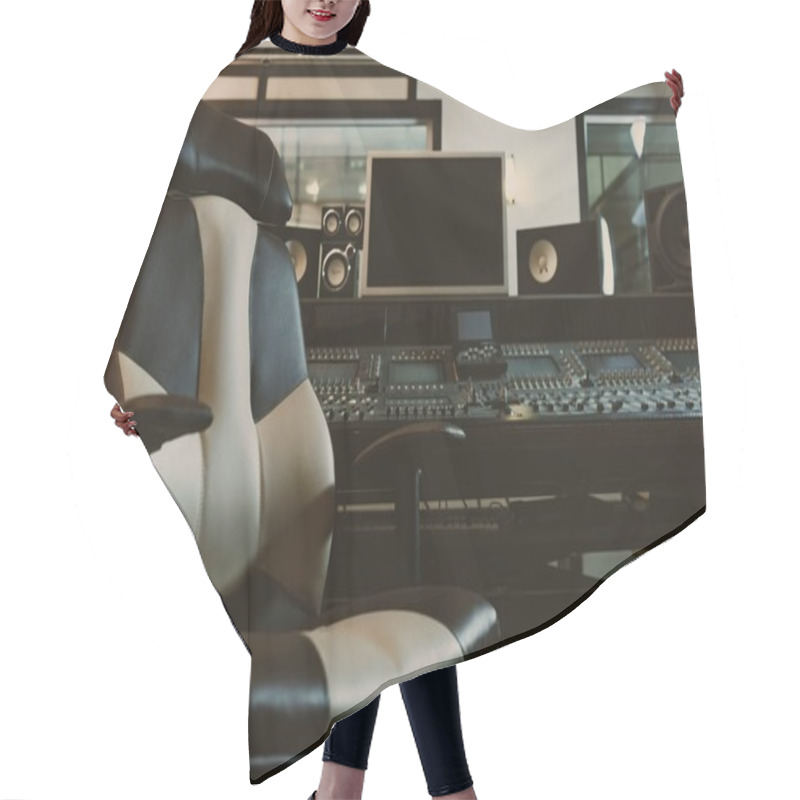 Personality  armchair in front of graphic equalizer at recording studio hair cutting cape