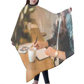 Personality  Female Freelancer Writing In Diary At Table With Coffee Cup And Business Newspaper In Coffee Shop Hair Cutting Cape