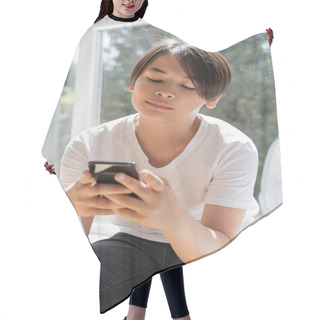 Personality  Preteen Asian Boy Using Smartphone While Sitting On Windowsill At Home  Hair Cutting Cape