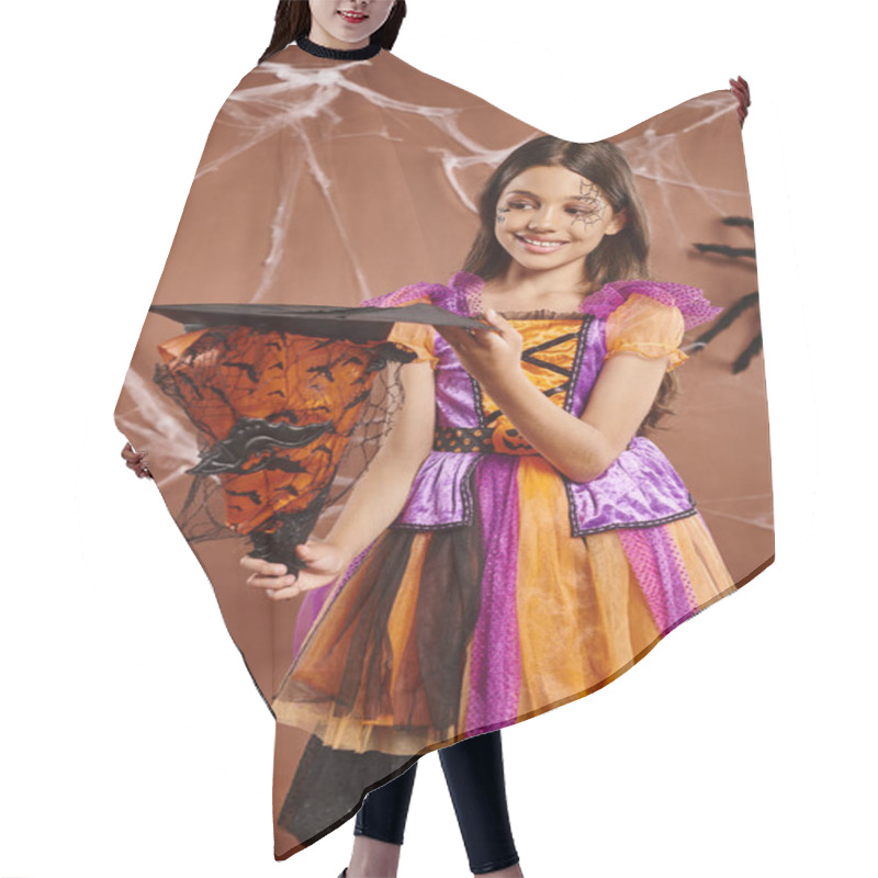 Personality  Cheerful Child In Halloween Witch Costume Holding Pointed Hat On Brown Background, Spooky Season Hair Cutting Cape