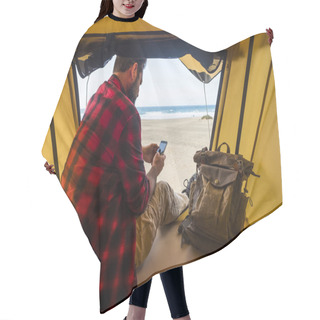Personality  Man Sit Down Inside A Tent On Wild Free Camping At The Beach Using Modern Connected Cellular Mobile Phone  Hair Cutting Cape