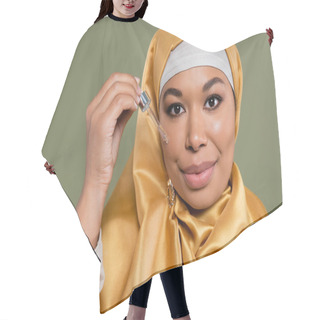 Personality  Portrait Of Multiracial Woman In Hijab Holding Dropper With Serum Isolated On Green  Hair Cutting Cape