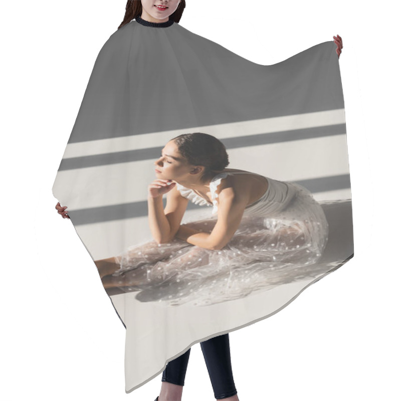 Personality  Side View Of Ballerina Bending While Sitting On Grey Background With Sunlight Hair Cutting Cape