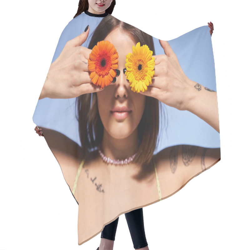 Personality  A Young Woman With Brunette Hair Holding Two Flowers In Front Of Her Eyes In A Studio Setting. Hair Cutting Cape