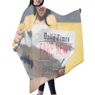 Personality  Cropped View Of Angry Asian Businesswoman Sitting On Yellow Sofa And Reading Newspaper With Fake News On Grey Background Hair Cutting Cape