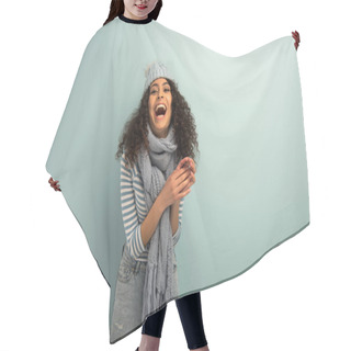 Personality  Excited Bi-racial Girl In Warm Hat And Scarf Laughing On Grey Background Hair Cutting Cape