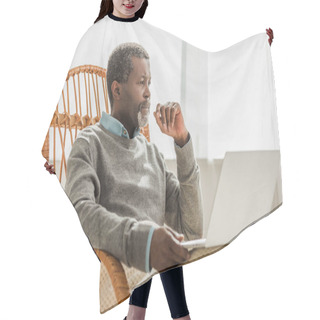 Personality  Dreamy African American Man Sitting In Wicker Chair With Laptop And Looking Away Hair Cutting Cape