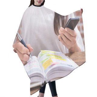 Personality  Close-up Of A Businesswoman Holding Cellphone Writing Schedule In The Diary With Pen Hair Cutting Cape