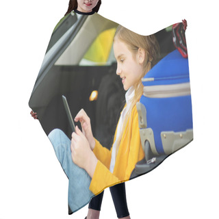 Personality  Adorable Little Girl Ready To Go On Vacations With Her Parents. Kid Sitting In A Car Trunk And Reading Her Ebook. Traveling By Car With Kids. Hair Cutting Cape