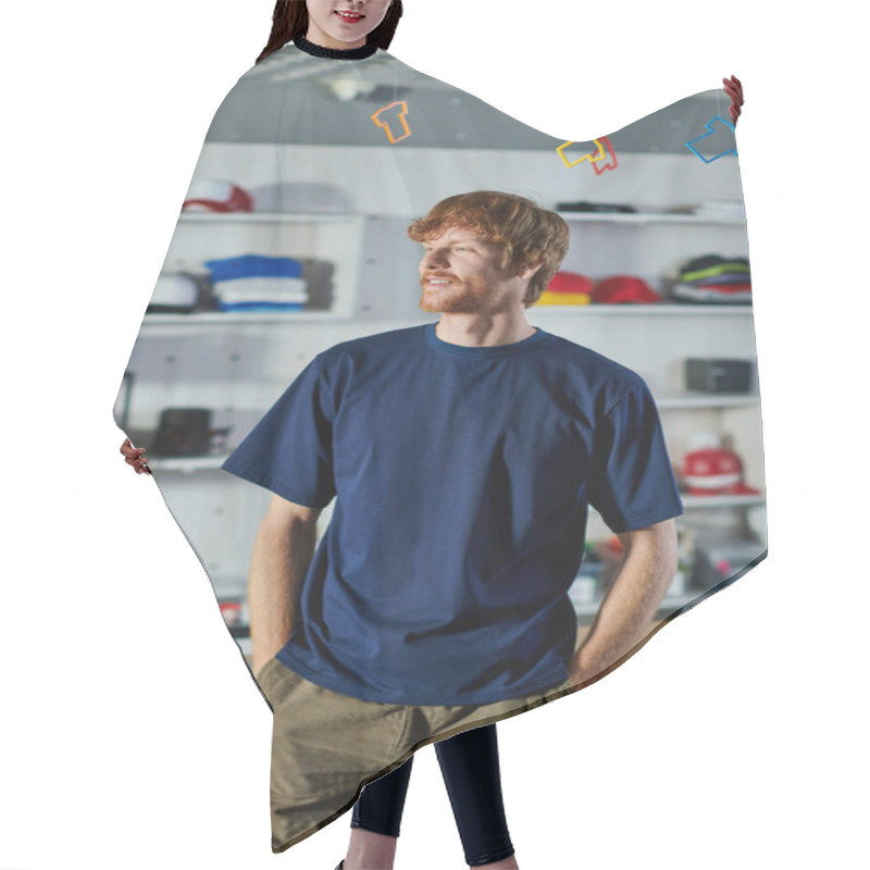 Personality  Young Redhead Designer In Casual Clothes Holding Hands In Pockets And Standing Near Working Table In Blurred Print Studio, Hands-on Entrepreneurship Concept  Hair Cutting Cape