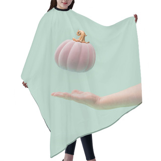 Personality  Pink Halloween Pumpkin With Golden Petiole Falling Into Women Arm. Green Mint Background. Minimal Design. Hair Cutting Cape
