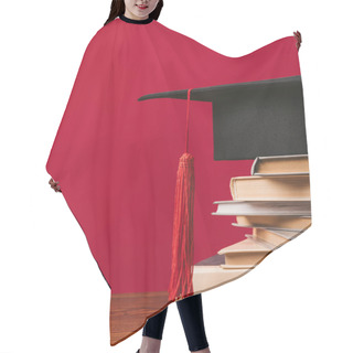 Personality  Cropped Image Of Academic Cap On Pile Of Books On Red Hair Cutting Cape