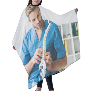 Personality  Bearded Doctor Touching Spine Model While Sitting In Armchair  Hair Cutting Cape