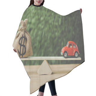 Personality  Toy Car And Money Bag With Dollar Sign Balancing On Seesaw On Green Background Hair Cutting Cape