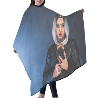 Personality  Young Woman In Witch Halloween Costume Holding Black Rose On Dark Background With Blue Fog Hair Cutting Cape