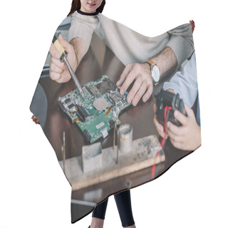 Personality  Cropped Image Of Father And Son Soldering Circuit Board With Soldering Iron At Home Hair Cutting Cape