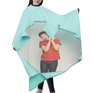 Personality  Shocked Asian Preteen Boy Red T-shirt Looking At Camera And Touching Hole In Blue Paper While Celebrating Child Protection Day On White Background Hair Cutting Cape