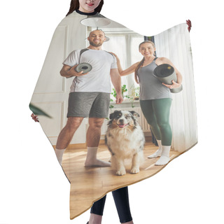 Personality  Smiling Couple In Sportswear Holding Fitness Mats And Looking At Camera Near Border Collie At Home Hair Cutting Cape