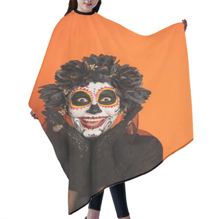 Personality  Excited Woman In Spooky Halloween Makeup And Black Wreath Holding Hands Near Face And Looking At Camera Isolated On Orange Hair Cutting Cape