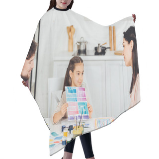 Personality  Cheerful Kid Holding Paper With Colorful Stripes Near Parents At Home  Hair Cutting Cape