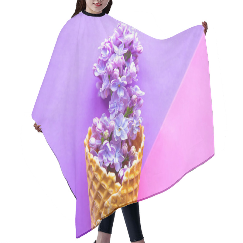 Personality  Lilac blooming branch in waffle cone on geometric purple background. Minimal concept hair cutting cape