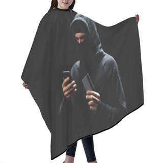 Personality  Hacker In Mask Using Smartphone And Holding Credit Card Isolated On Black  Hair Cutting Cape