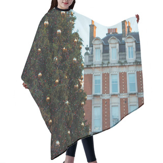 Personality  A Large Christmas Tree Adorned With Gold Baubles And Fairy Lights Stands In London, UK, Against A Backdrop Of Red Brick Townhouses With Whitetrimmed Windows Under An Overcast Winter Sky. Hair Cutting Cape