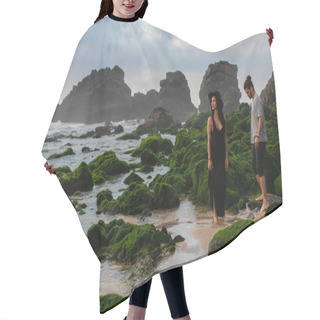 Personality  Tattooed Woman In Hat And Dress Standing Near Bearded Man And Mossy Stones In Ocean  Hair Cutting Cape